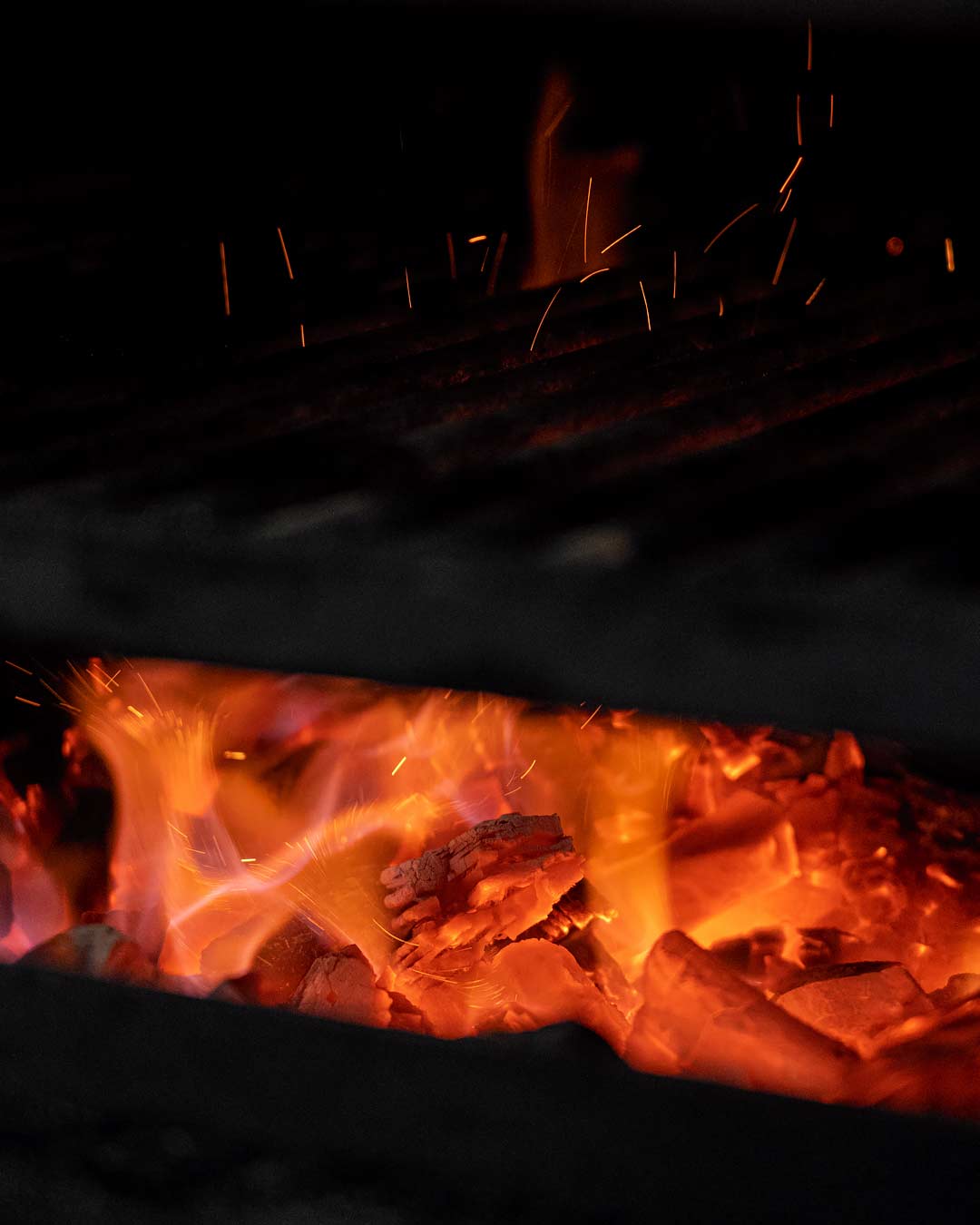 Fotografia de detall del forn de brasa encés.