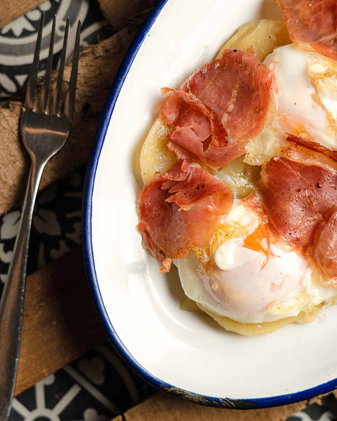 Foto gastronòmica d'ous estrellats amb pernil.